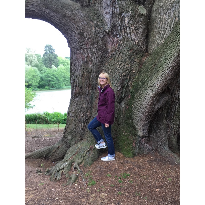 Karen McKenzie by a large tree trunk